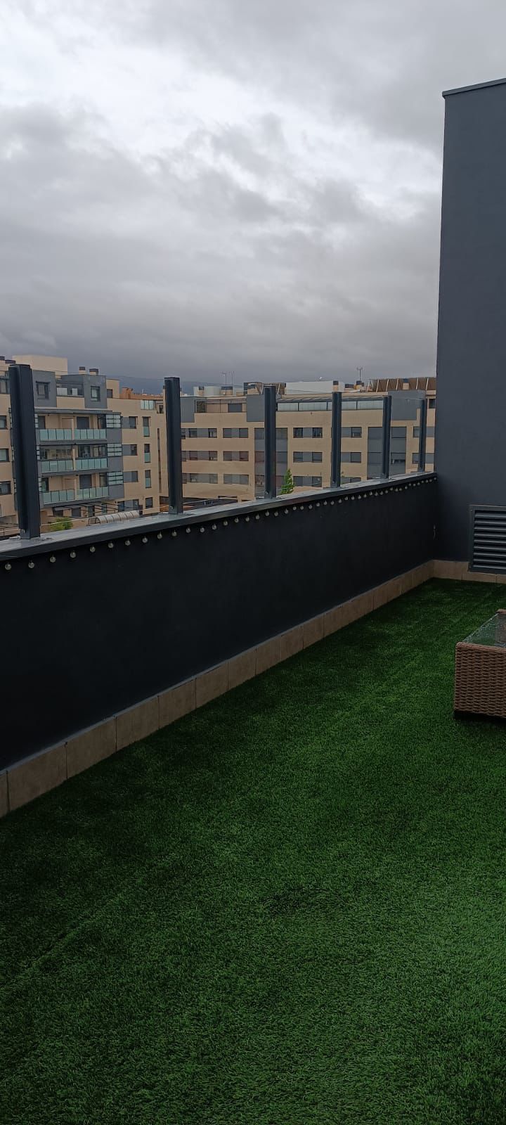 Barandilla de cristal con pinzas en terraza de ático