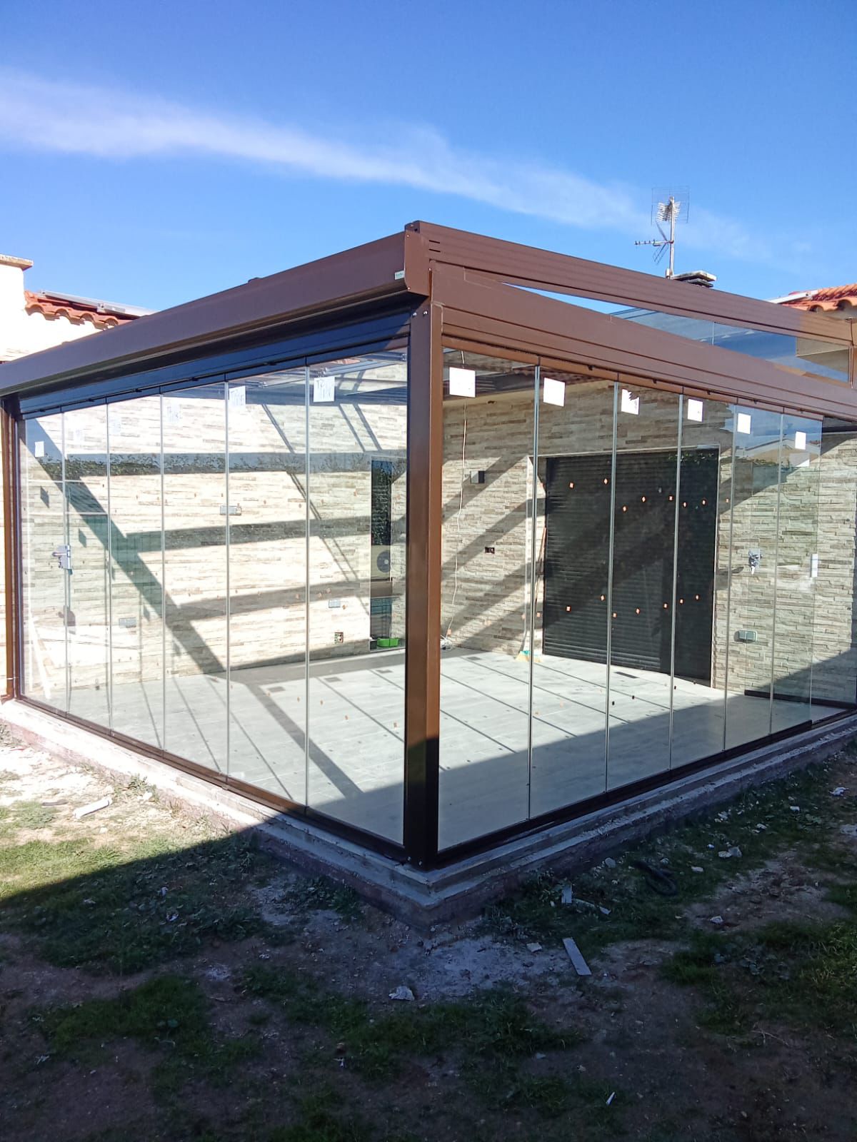 Cerramiento de porche con pérgola y cortinas de cristal