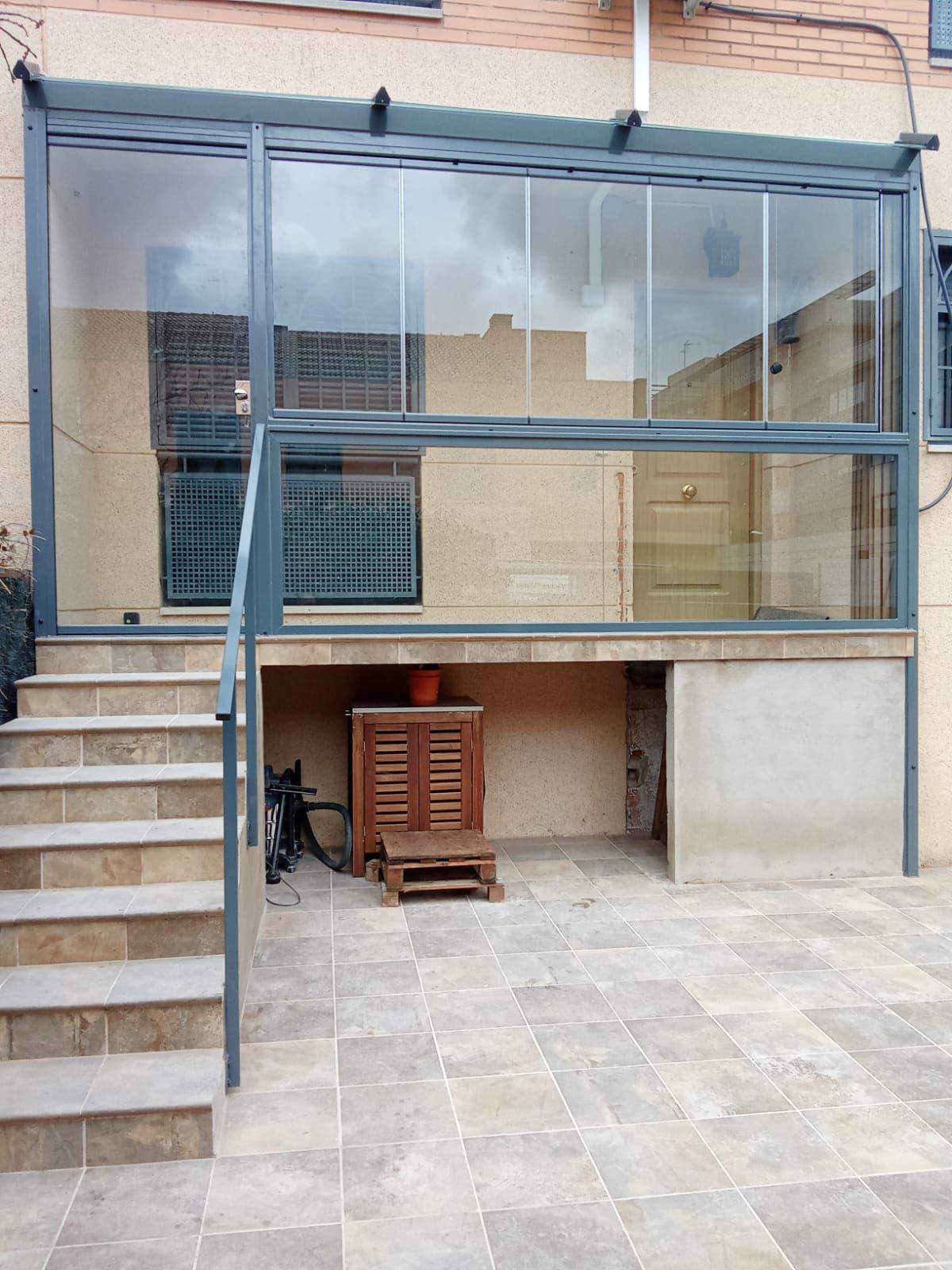 Cerramiento de porche con estructura metálica y cortina de cristal