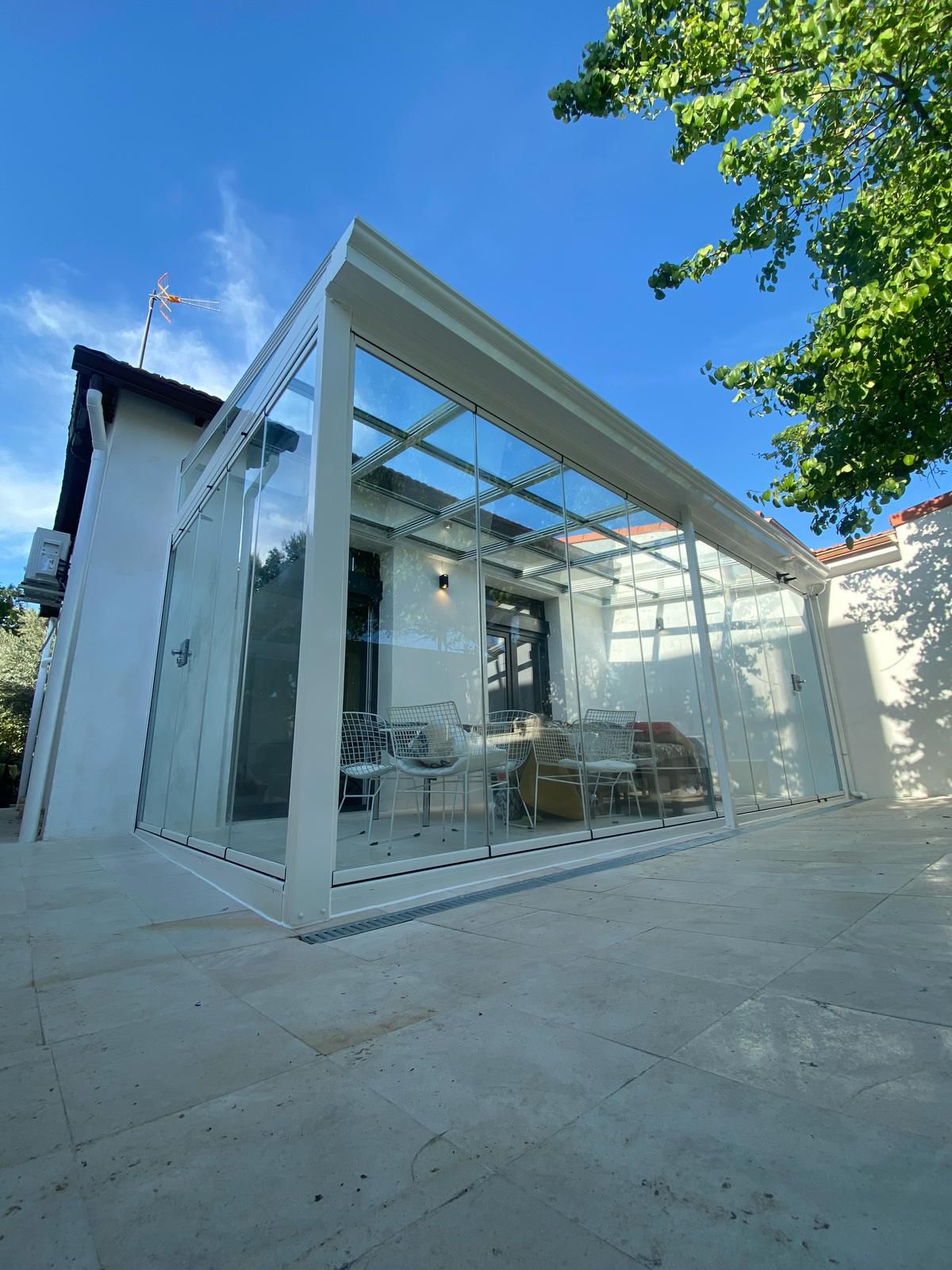 Cerramiento de patio con techo fijo de cristal y cortinas