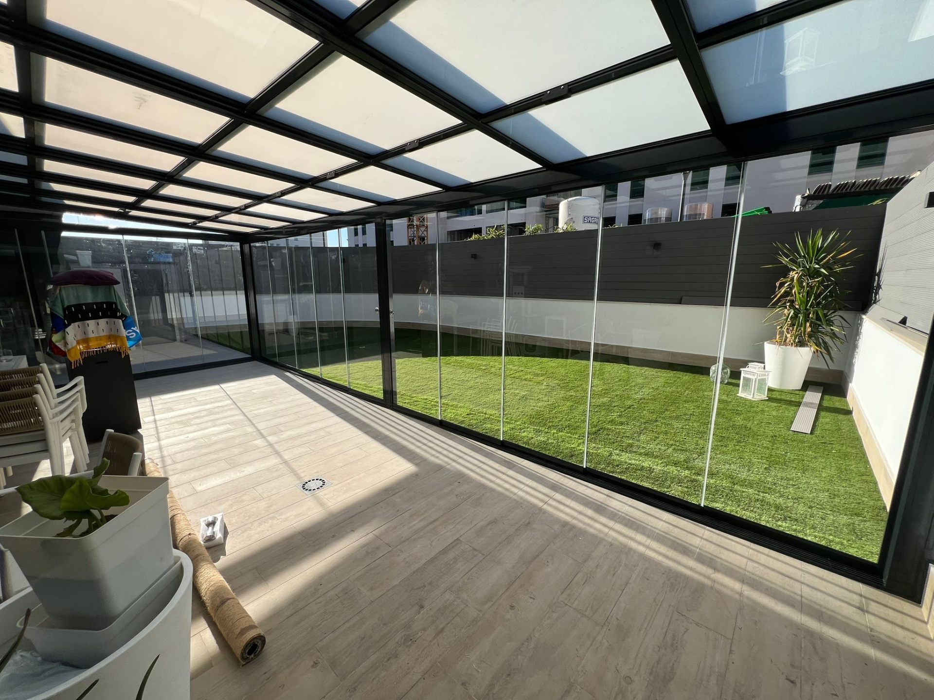 Ático cerrado con techo de cristal y vistas a jardín