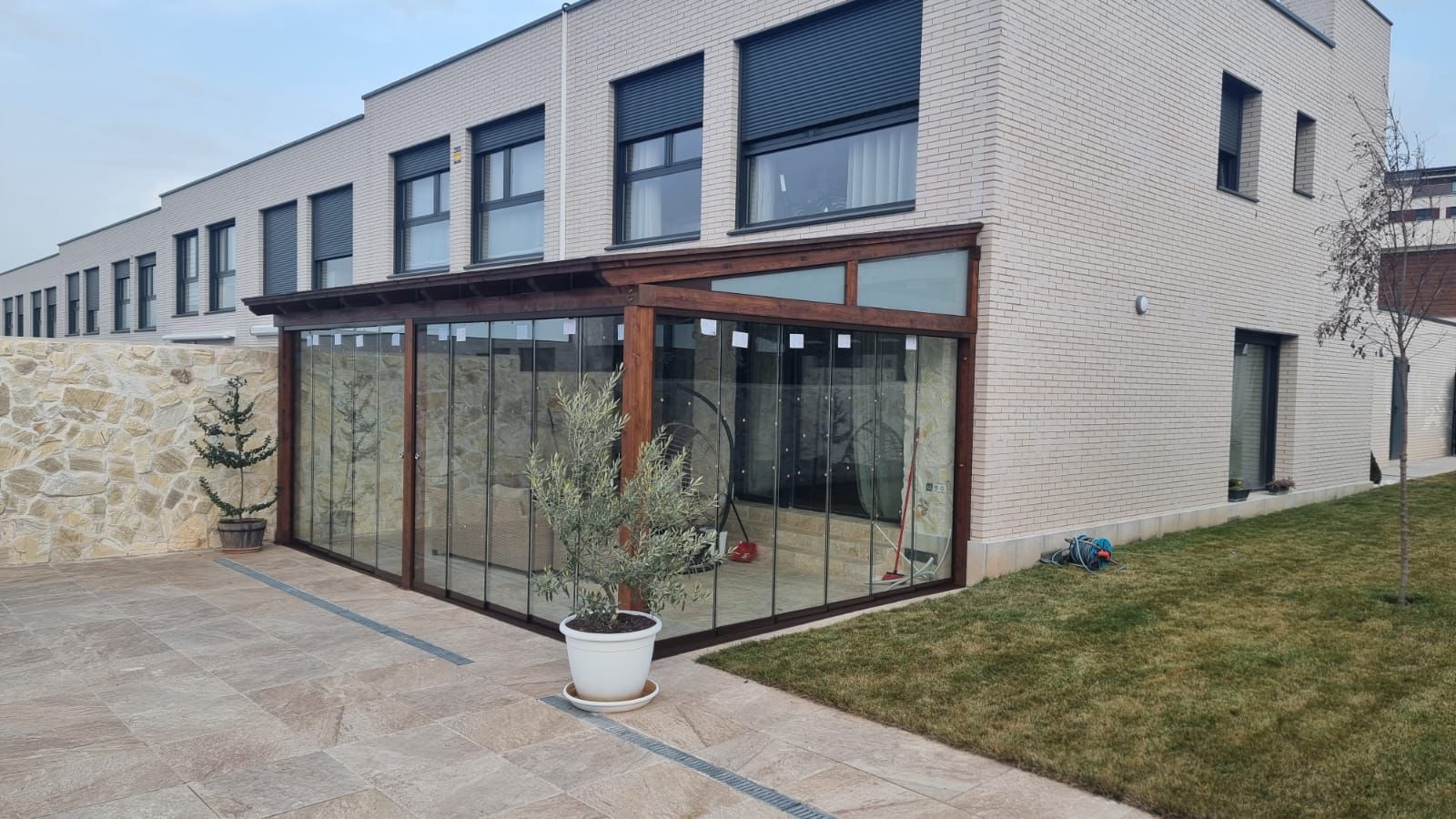 Cerramiento de porche con cortinas de cristal y madera