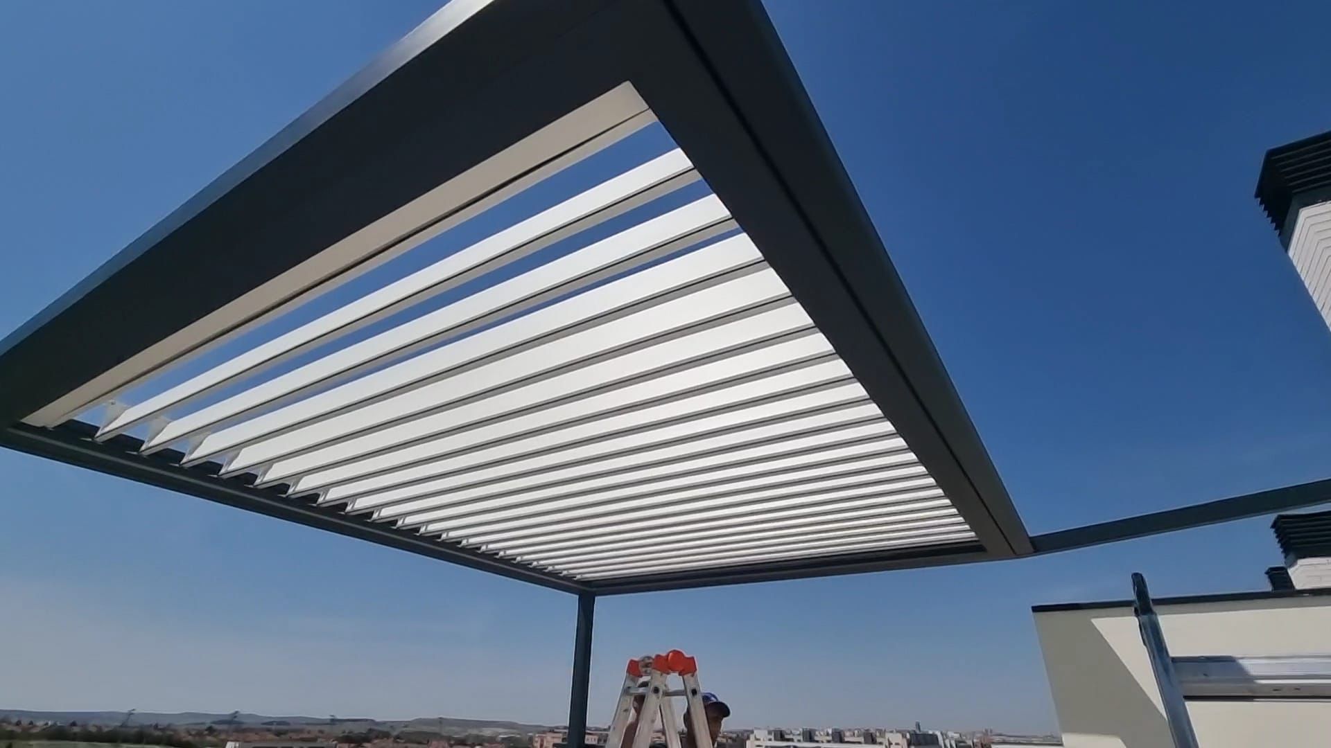Pérgola bioclimática con lamas abiertas en terraza