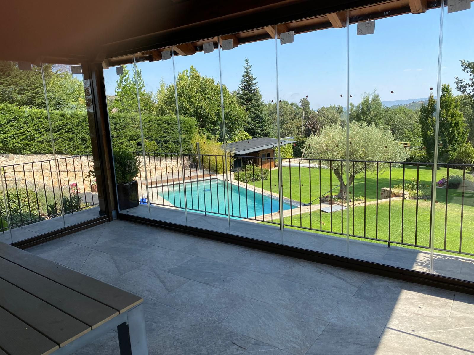 Cortina de cristal en porche con vistas a piscina y sierra
