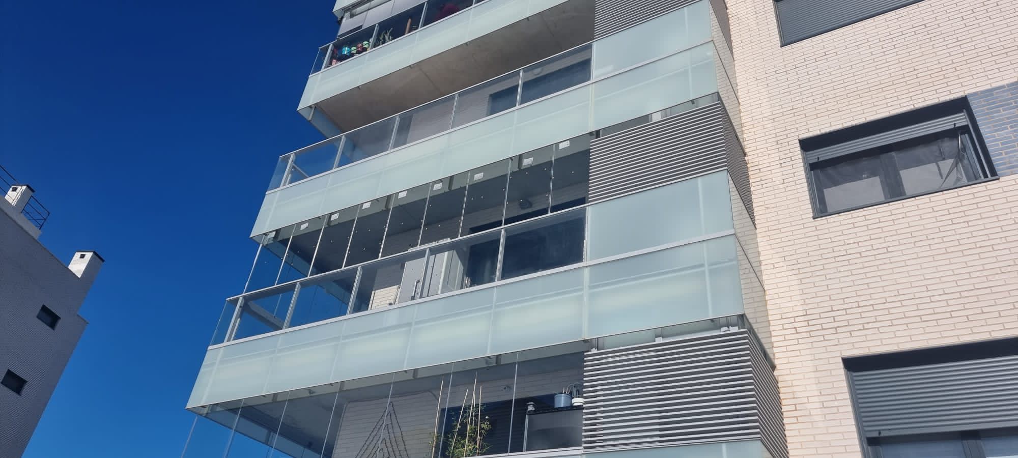 Cortinas de cristal en balcones de edificio residencial
