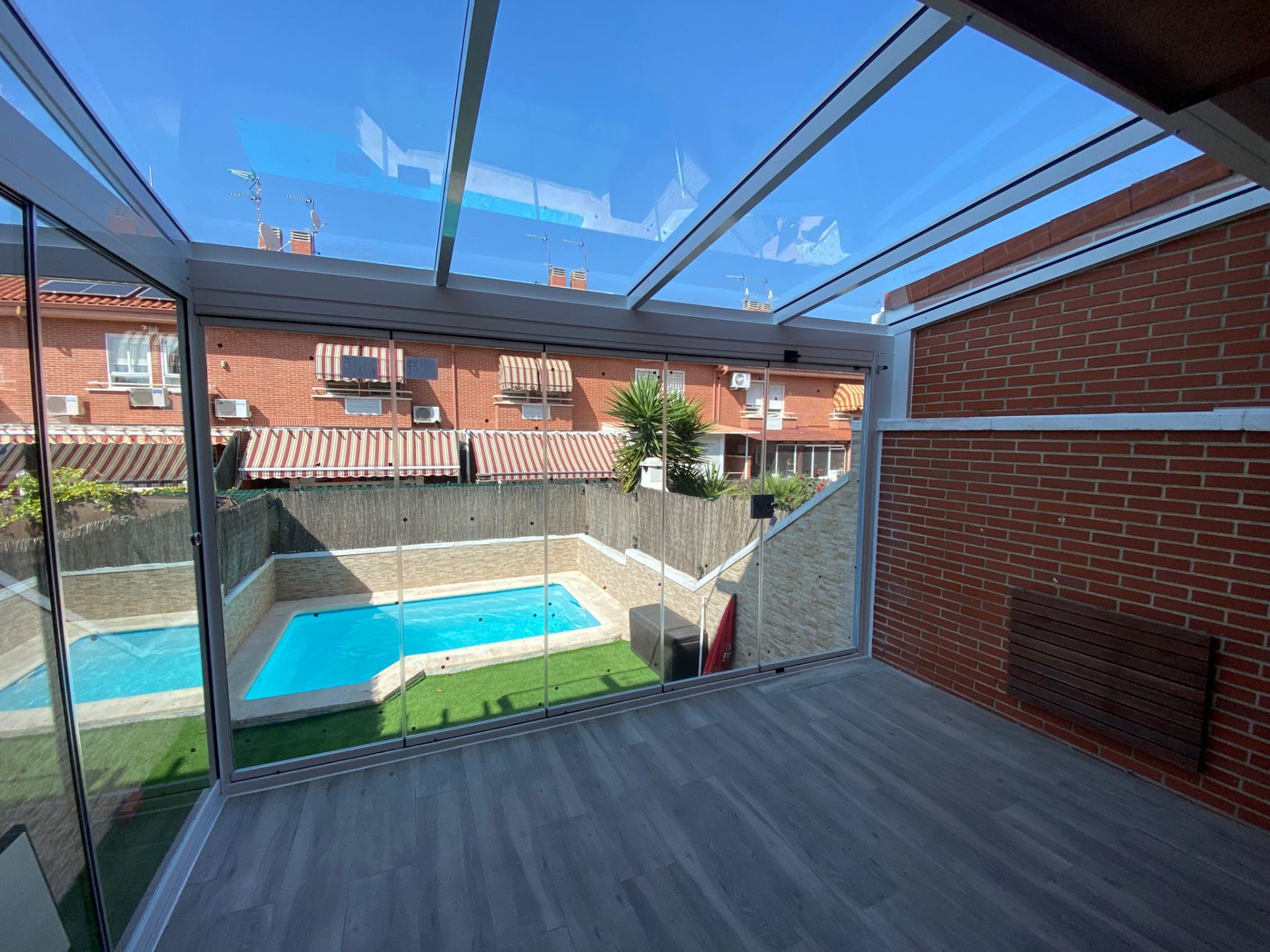 Cerramiento de terraza con techo de cristal y vistas a piscina